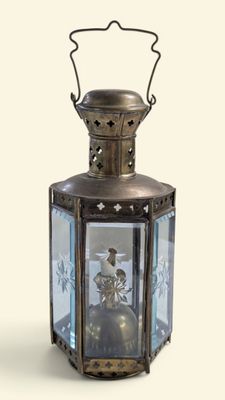 une petite lanterne en métal avec un couvercle en verre