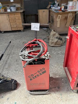 deux bacs rouges contenant des outils, dans un garage