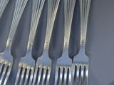 a lot of forks and spoons that are on the table