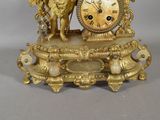 a gold clock with a statue of a man and a dog on it