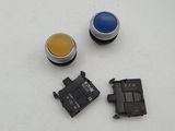 three different colored buttons are shown on a white surface