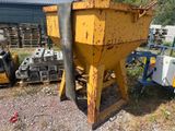 a yellow dump truck parked next to a pile of concrete blocks