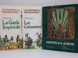 trois livres, regroupés sous une même couverture, sont posés sur une surface blanche