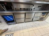 a large stainless steel kitchen with a blue trash can in it
