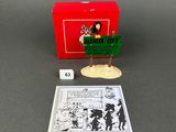 a box with a toy figure of a man holding a sign next to it