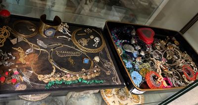 deux présentoirs de bijoux exposés dans une vitrine en verre