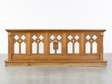 une image représentant un banc en bois surmonté de fenêtres cintrées