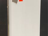 an image of a white refrigerator with a red sticker on it