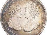 a close up of a coin with two women on it