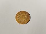 a close up of a gold coin on a white surface
