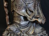 bronze statue of a person holding a shield and a shield