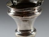 a silver vase that is sitting on a table