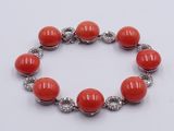 a bracelet with red coral beads and silver beads