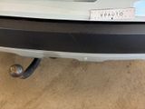the rear end of a white car with a sticker on it ' s bumper