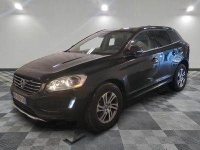 Le SUV Volvo noir est garé sur un sol en carrelage à damier.