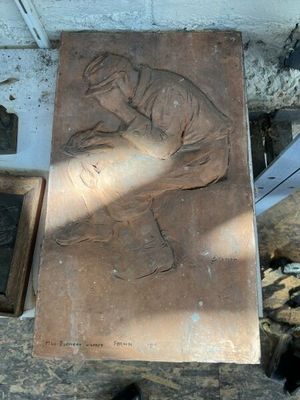 une sculpture en pierre représentant un homme agenouillé sur un banc