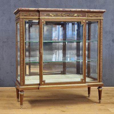 an old wooden display case with glass doors on top of a wooden floor
