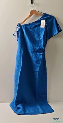 an image of a blue dress hanging on a hanger on a wall