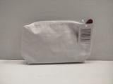 un sac à main blanc muni d'une étiquette, posé sur une table