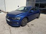 une Volkswagen Golf bleue garée devant un immeuble