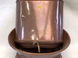 une petite casserole en cuivre avec un couvercle dessus