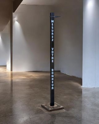a tall black sign in the middle of a room