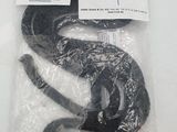 a black snake wrapped in plastic on a white surface