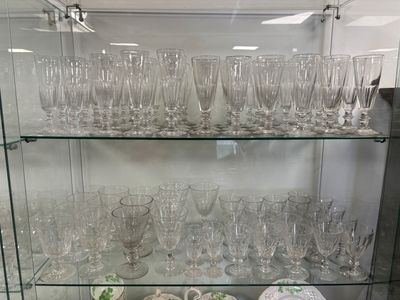 beaucoup de verres posés sur une étagère en verre dans une pièce