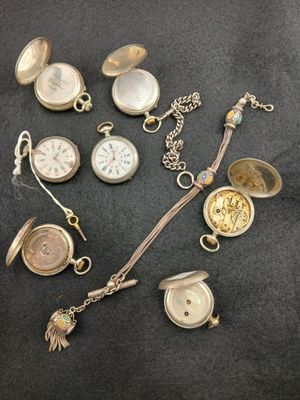 many different types of pocket watches on the table