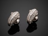 a pair of diamond earrings on a black surface