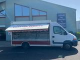 un petit food truck garé devant un immeuble