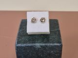 pair of diamond stud earrings on display on a marble block