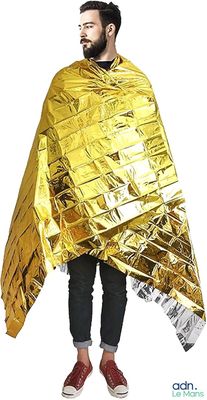 un homme vêtu d’une tenue en papier d’aluminium doré, debout, les mains sur les hanches