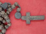 un chapelet et une croix posés sur un tissu rouge