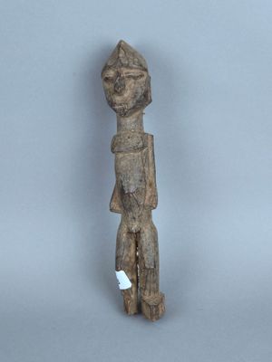 une vieille statue en bois d'un homme avec un chapeau sur la tête