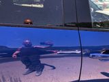 a reflection of a man on the side of a car