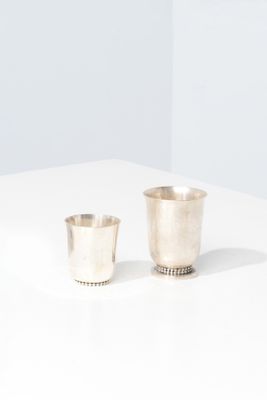 a pair of silver cups on a white surface