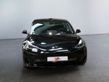 a black tesla model s parked in a showroom