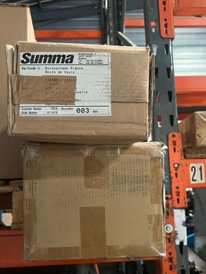 Les cartons sont empilés les uns sur les autres sur une étagère dans un entrepôt
