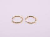 une paire de boucles d'oreilles en or sur fond blanc