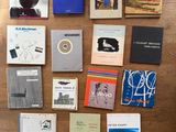 Plusieurs livres sont disposés sur une table en bois, sur un sol en bois.