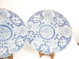 pair of blue and white plates on wooden stands on a white surface
