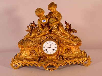 une horloge en or surmontée d'une statue