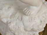 a statue of a child holding a flower on a rock