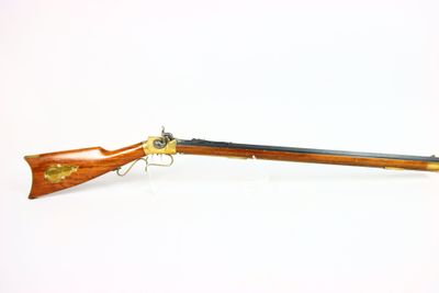 un vieux fusil au canon en bois et aux garnitures en laiton
