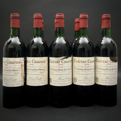 quatre bouteilles de vin rouge sont alignées sur une surface noire
