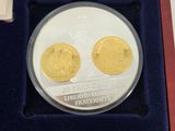 the two gold coins are in a red box on the table
