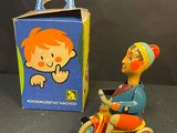 a small toy figurine of a man riding a tricycle