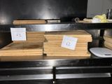 several stacks of wood are stacked on top of a metal shelf