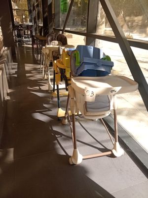 une chaise haute au milieu d'une rangée de chaises